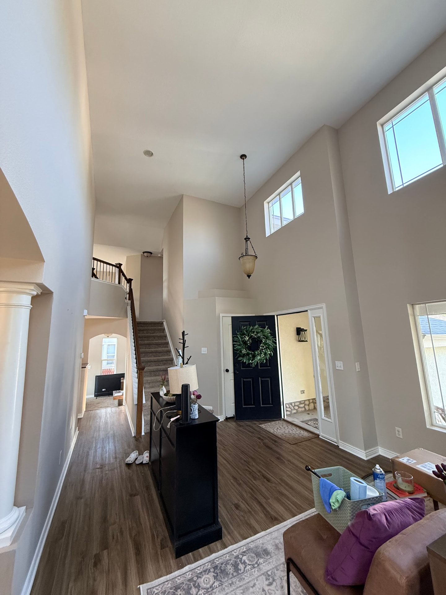 A bright two-story entryway with freshly painted walls and wood-look flooring