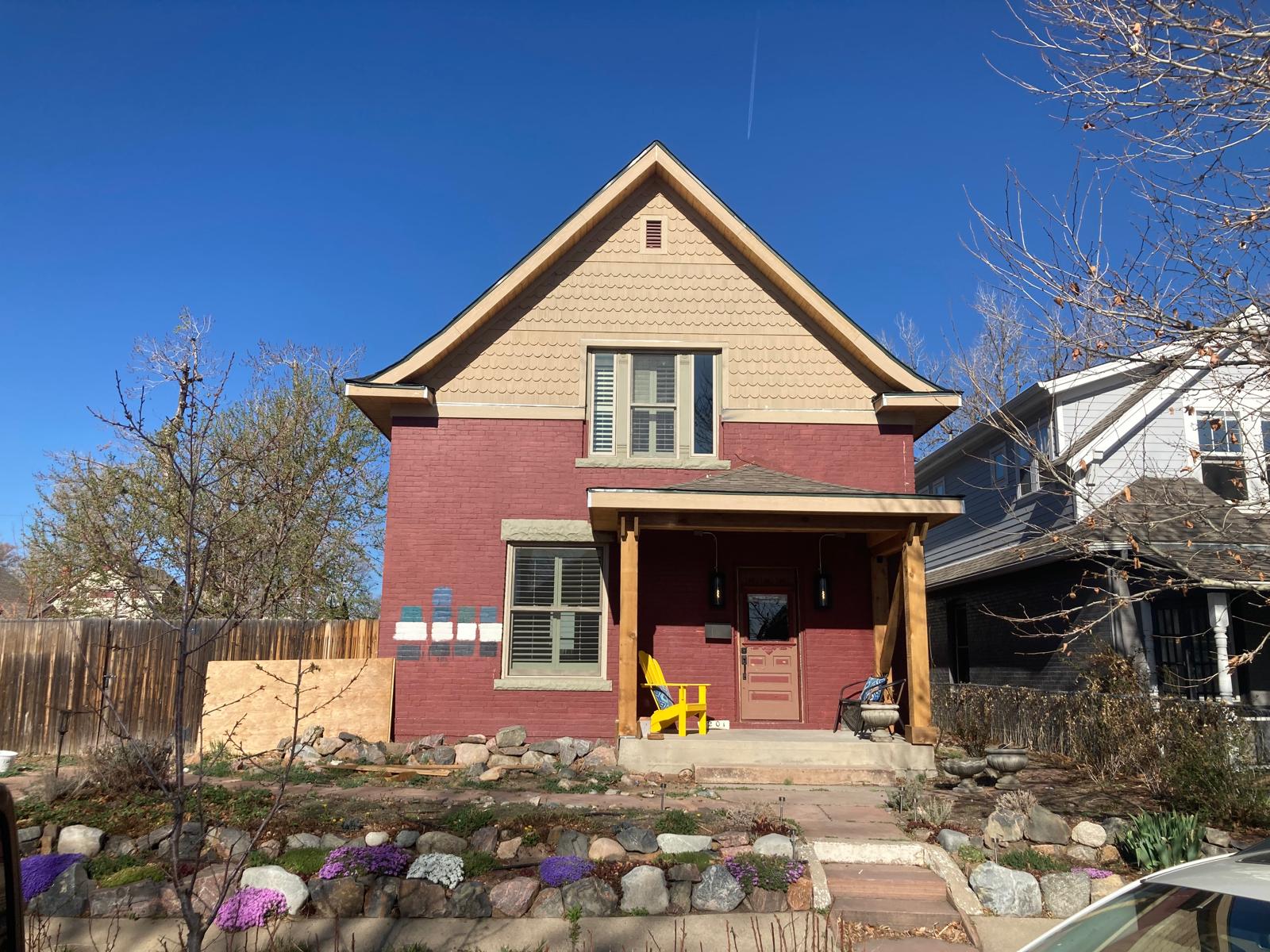 A two-story red brick home with a gabled front and a covered porch