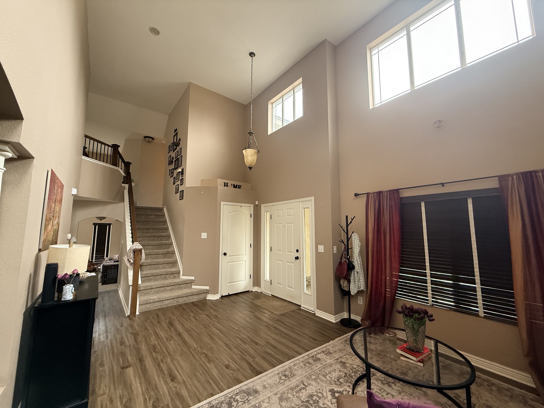 A vaulted living room with a staircase, pendant light and freshly painted walls