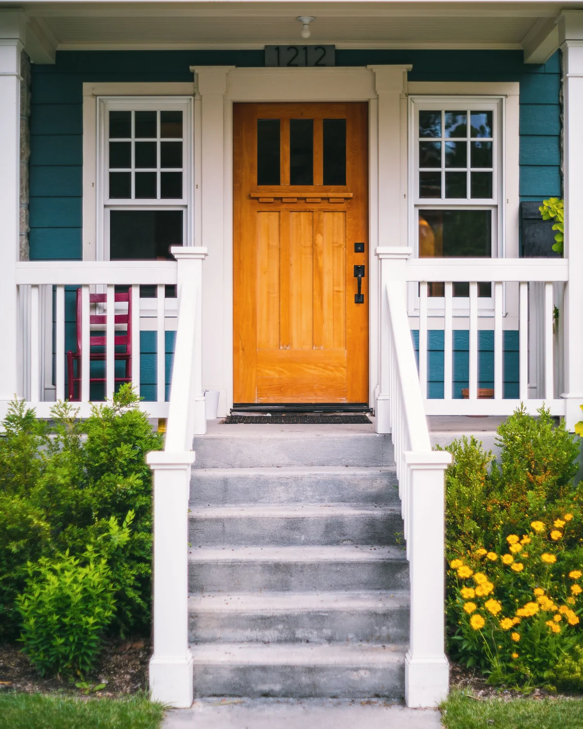 A freshly finished front porch with a stained wood door and crisp white trim